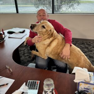 Ralph Strozza with his office companion, Payton, reflecting legacy leadership