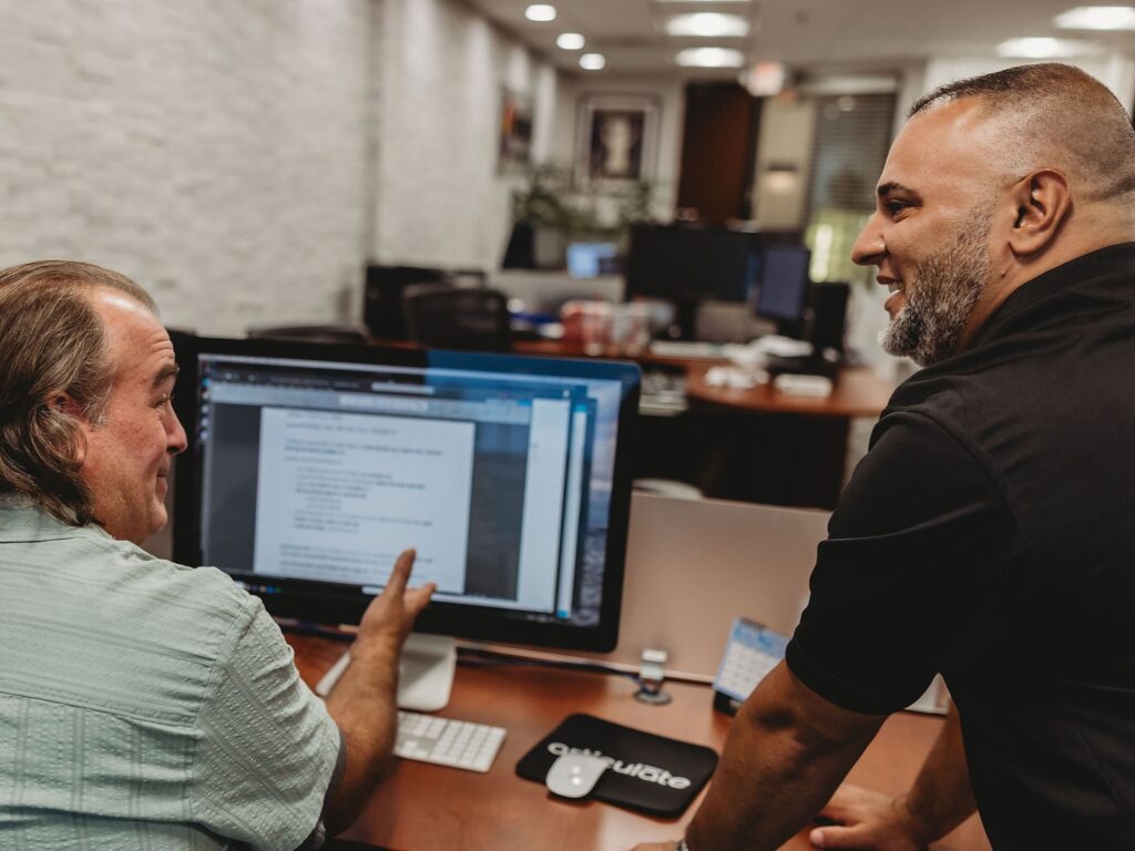 Two translation professionals collaborating at a computer in the Interpro office