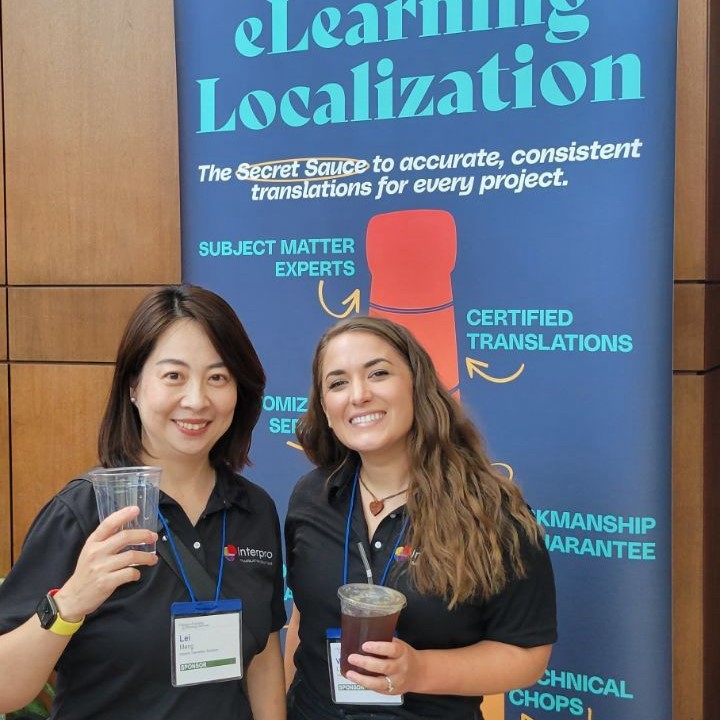 Lei Meng and Valerie Lagenux holding drinks and smiling at a conference