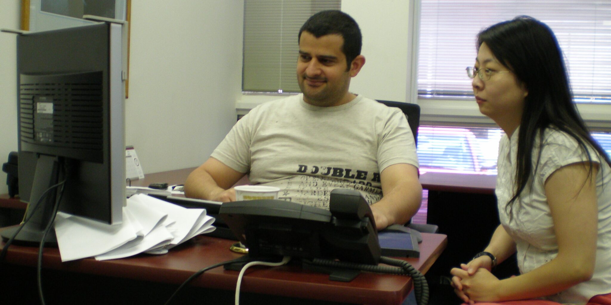 Beshar Bahjat and Colleague Looking at a Computer in the Office