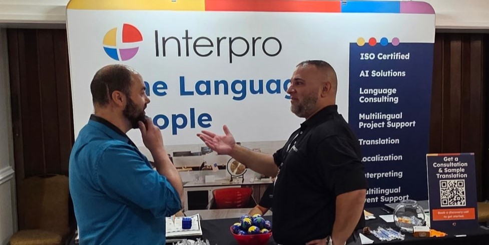 Landon Amaral discusses AI in L&D and translation solutions with an attendee at ATD New England, highlighting professional development trends