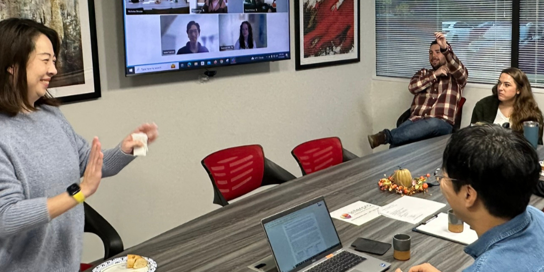 Lei Meng leading a hybrid client consultation in a conference room