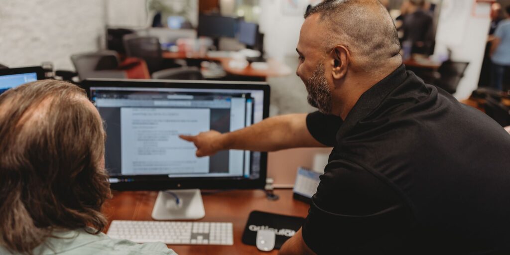 Two Interpro team members reviewing AI-generated translation output together on-screen to ensure accuracy and clarity through human oversight for ethical AI translation.