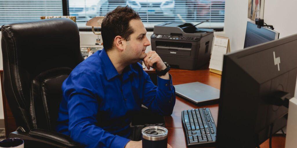 Person in Interpro shirt sitting at desk working on computer