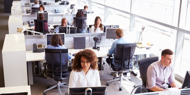 Employees working in an open office using AI translation tools for internal communication