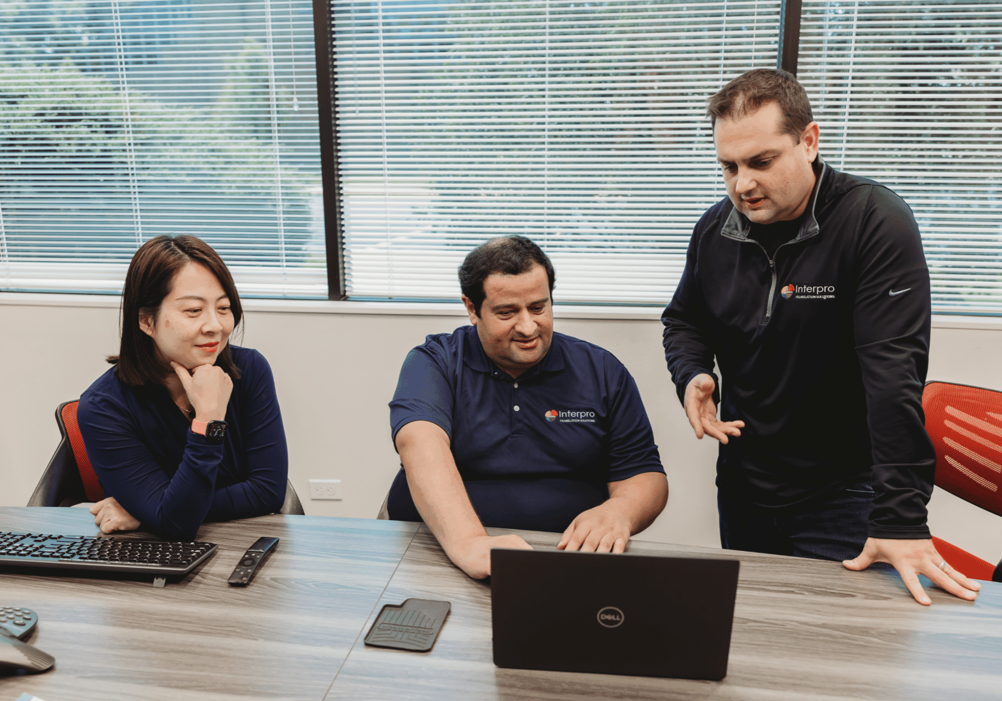 Interpro Language Consulting Team Interpro Translation Solutions team collaborating on localization strategy around a laptop in the office